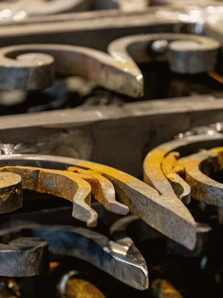 Hand-forged iron scroll pieces on the workbench