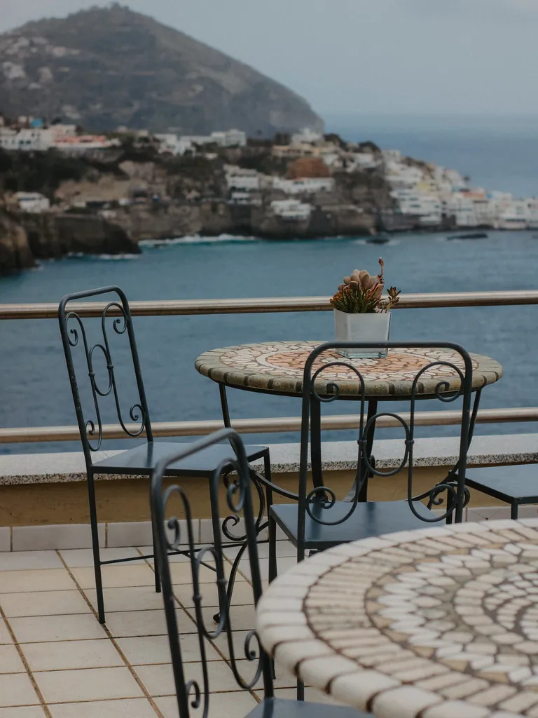 Wrought iron mosaic-top table and chairs on a sea-view terrace
