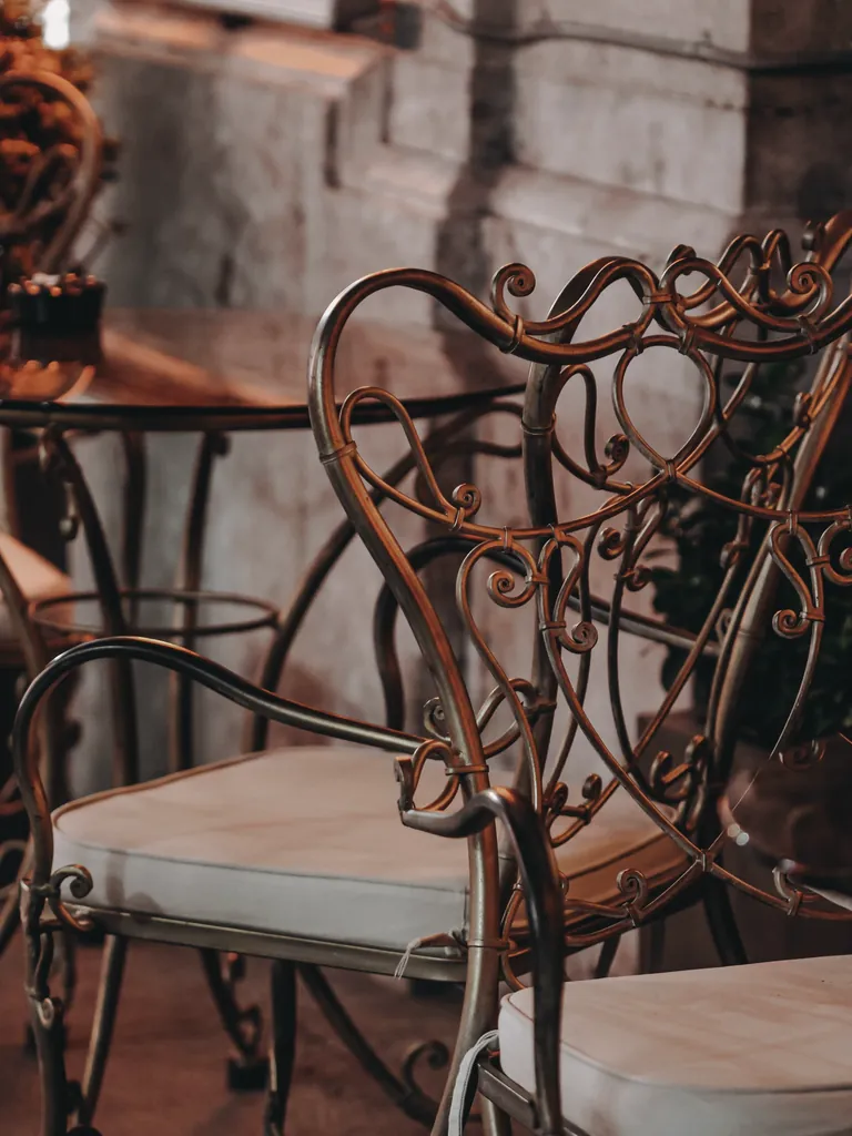 Wrought iron armchair with a scrolled back and cushioned seat